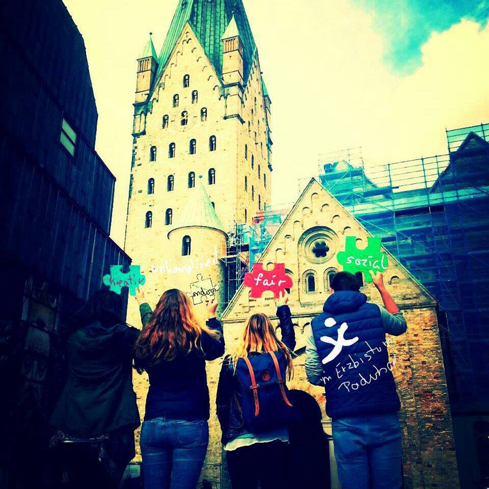 Jugendliche mit Puzzleteil vor dem Dom in Paderborn